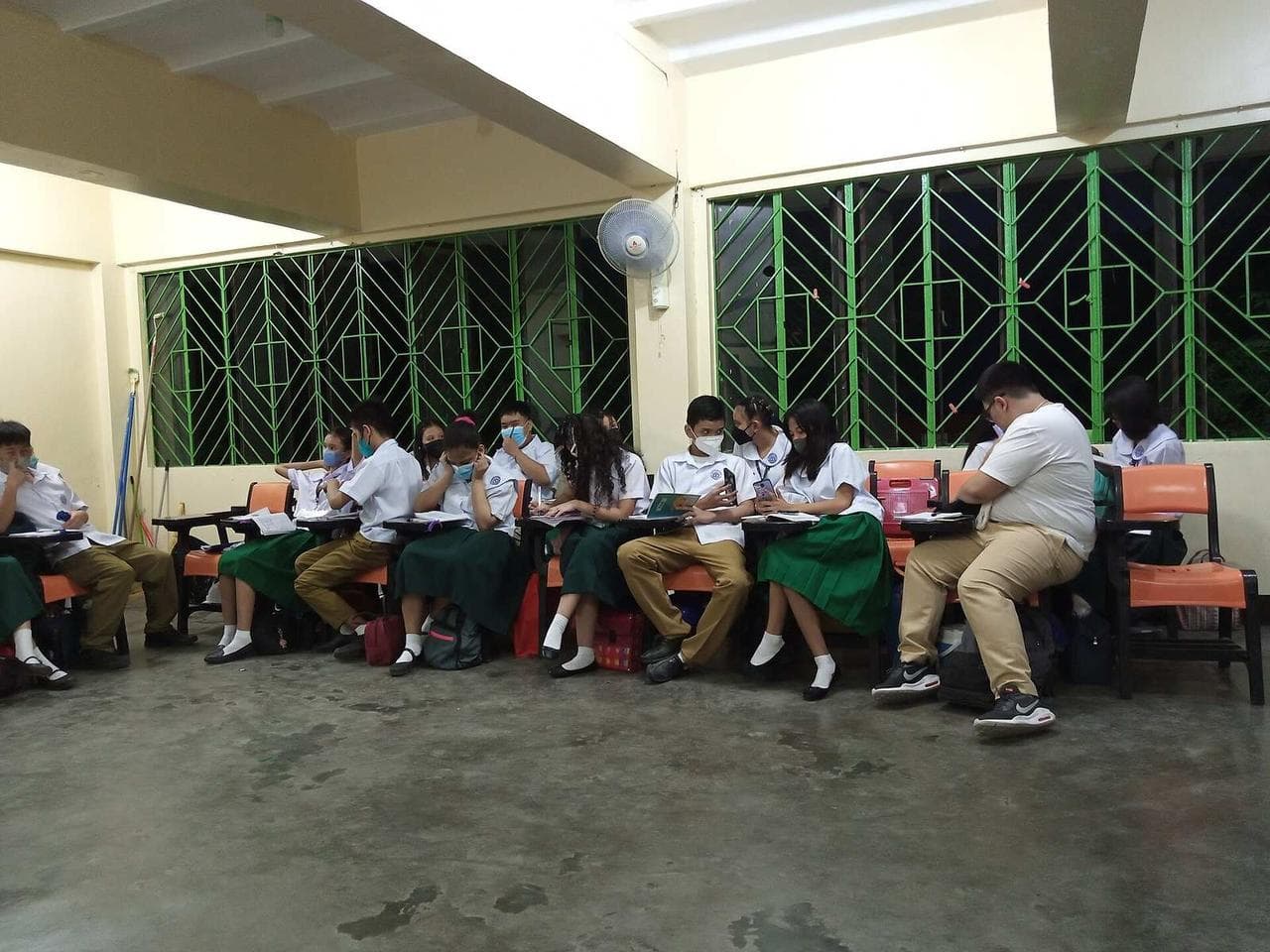 Filipino high school students in uniform reading their notes in a classroom at Caloocan High School