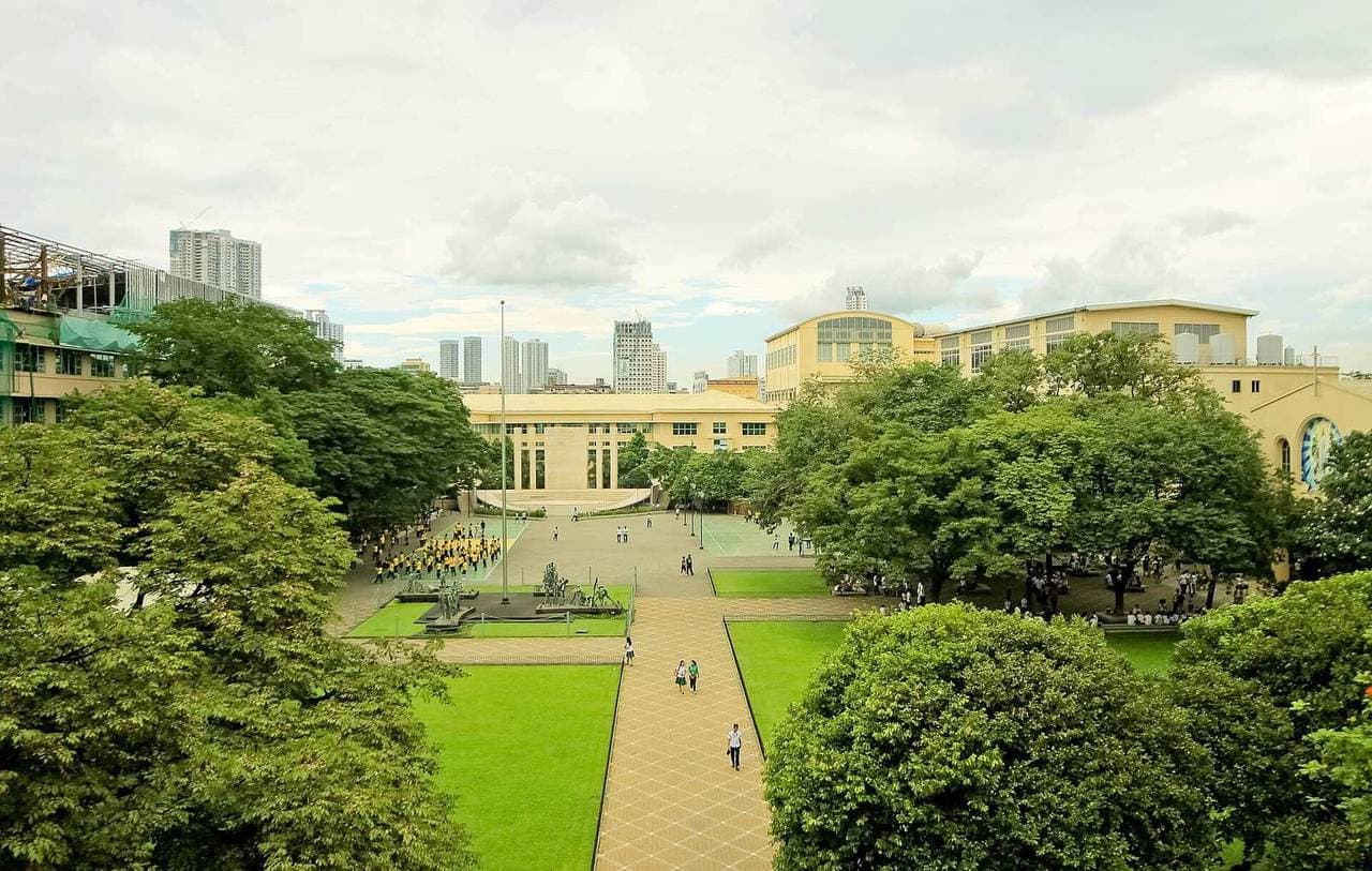 Students walking across the tree-lined quadrangle of Far Eastern University in Sampaloc, Manila