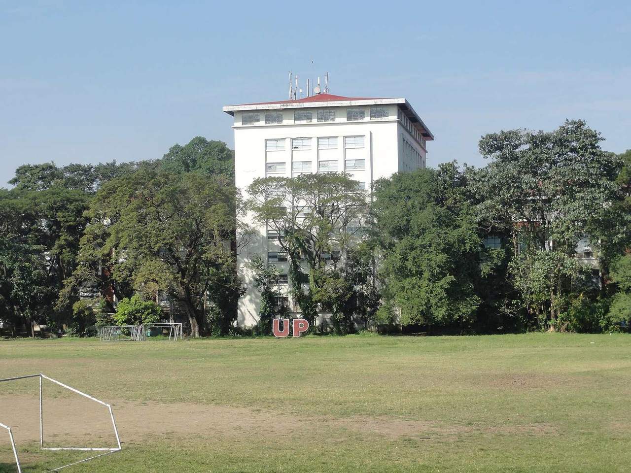 The University of the Philippines Diliman Main Library rising above the trees beside the Sunken Garden